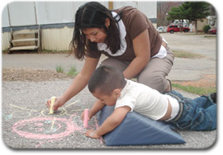 child drawign with chalk using a wedge adaptation